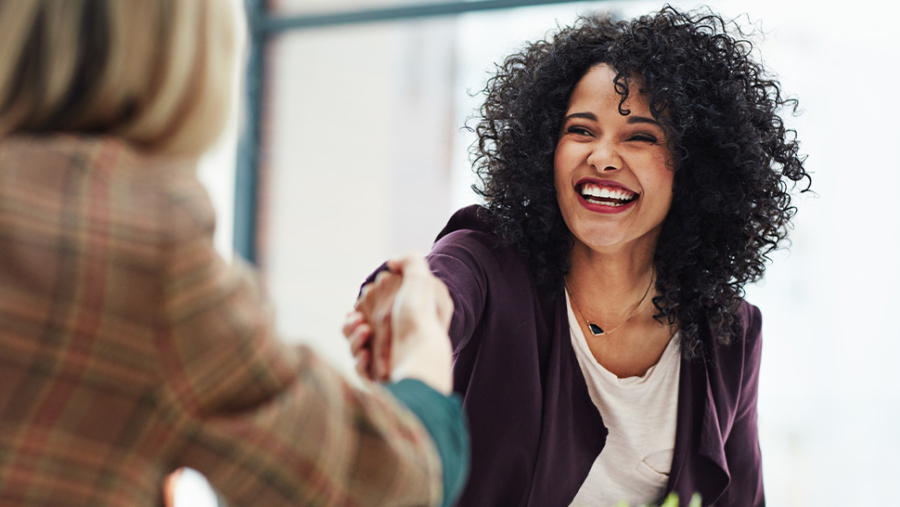 Women shaking hands and smiling