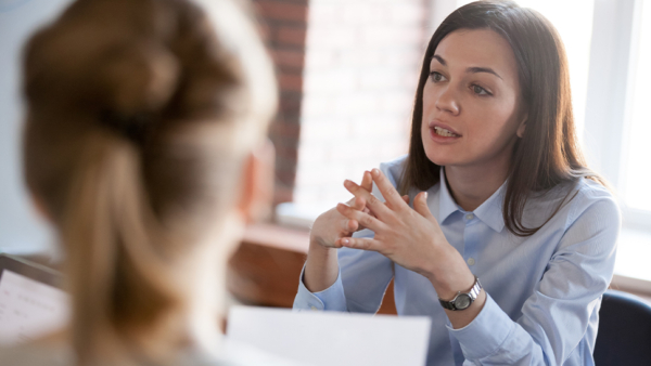 woman sat opposite sides of the table talking