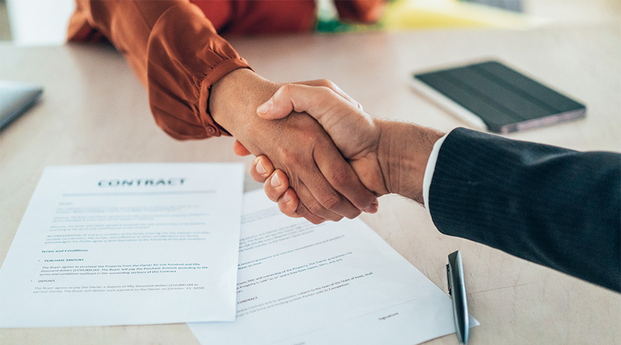 Two hands shaking over a document